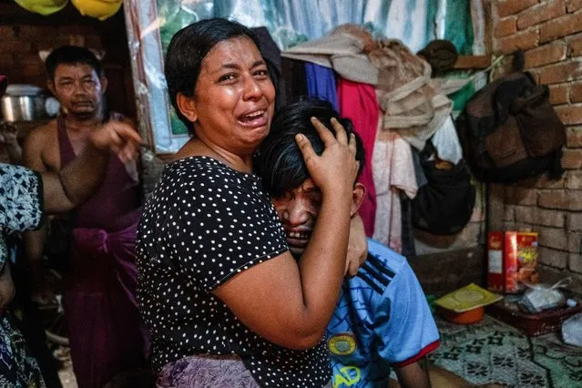 Family members cry in front of a man after he was shot dead during a crackdown on an anti-coup protesters by security forces in Yangon, Myanmar, March 27, 2021. (Photo by Reuters/Stringer)