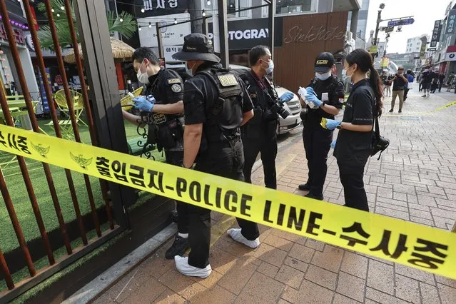 Police officers investigate the scene of a stabbing rampage on a street in Seoul, South Korea, Friday, July 21, 2023. A knife-wielding man stabbed at least four pedestrians on a street in the South Korean capital, Seoul, on Friday, killing one person, police said. (Photo by Shin Hyun-woo/Yonhap via AP Photo)