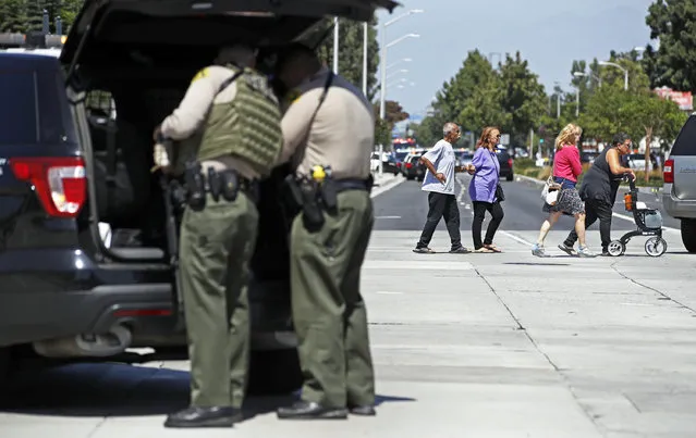 People are evacuated as Los Angeles County Sheriff's deputies prepare to stand guard at Kaiser Permanente Downey Medical Center, following reports of someone with a weapon at the facility in Downey, Calif., Tuesday, September 11, 2018. Los Angeles County sheriff's officials say a suspect is in custody and deputies and police officers are methodically searching the complex. (Photo by Jae C. Hong/AP Photo)