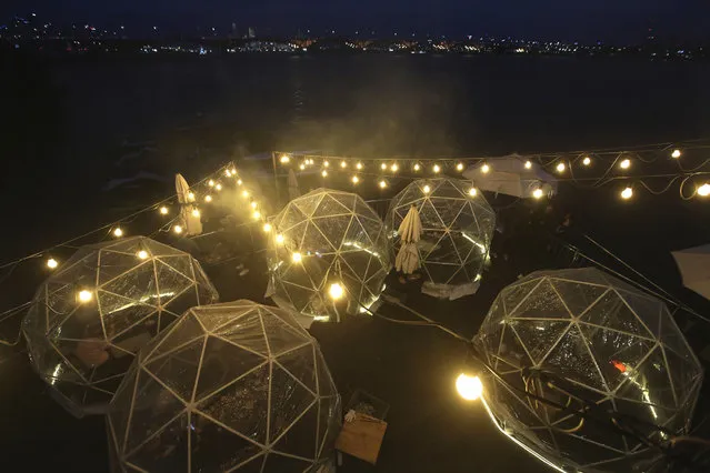 People enjoy outdoor dining at plastic bubbles, observing social distancing against the spread of the coronavirus at a restaurant near the Han River in Seoul, South Korea, Friday, April 9, 2021. (Photo by Ahn Young-joon/AP Photo)