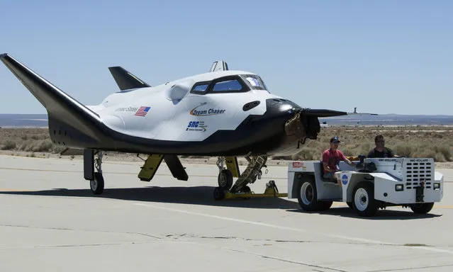 In this June 27, 2013 photo provided by NASA, Sierra Nevada Corp. engineers and technicians prepare the Dream Chaser engineering test vehicle for tow tests at NASA's Dryden Flight Research Center in California. On Thursday, January 14, 2016, NASA announced the Sierra Nevada Corp. will join SpaceX and Orbital ATK in launching cargo to the International Space Station. These flights, yet to be finalized, will run through 2024. (Photo by Ken Ulbrich/NASA via AP Photo)