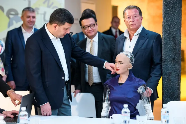Ukrainian Prime Minister Volodymyr Groysman touches social humanoid robot Sophia, a latest creation by Hanson Robotics company, during a meeting with young inventors and officials in Kiev, Ukraine October 11, 2018. (Photo by Vladyslav Musiienko/Reuters/Pool)