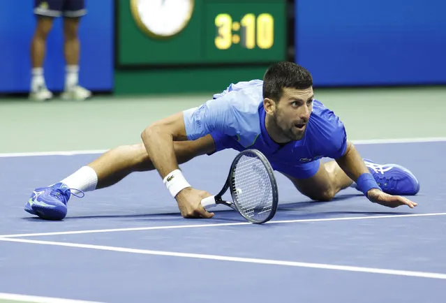 Serbia's Novak Djokovic watches his shot while falling on the court as he plays Russia's Daniil Medvedev in the US Open tennis tournament men's singles final match at the USTA Billie Jean King National Tennis Center in New York on September 10, 2023. (Photo by Kena Betancur/AFP Photo)
