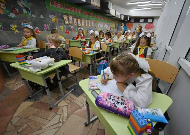 Pupils of the first grade attend a lesson in a classroom set up in a subway station in Kharkiv, on September 4, 2023, amid the Russian invasion of Ukraine. Children in Kharkiv attend classes online from their homes, or on subway stations where studying spaces were arranged for them following the city's schools closure due to a constant threat of Russian shelling and the lack of bomb-shelters. (Photo by Sergey Bobok/AFP Photo)