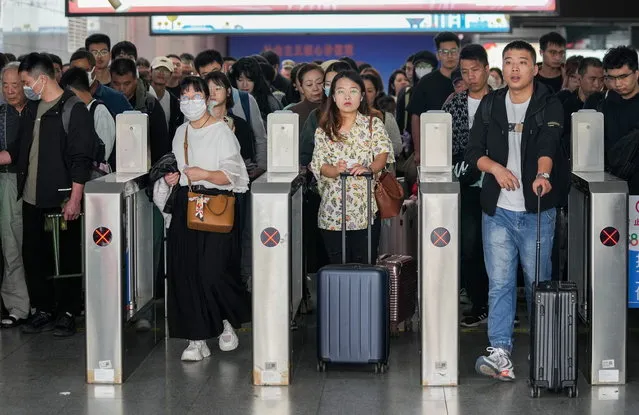 Travelers go through gateways at an exit in Shanghai Railway Station in Shanghai, east China, 06 October 2023. The day marks the last day of the Mid-Autumn Festival and National Day holiday. (Photo by EPA/Xinhua News Agency)