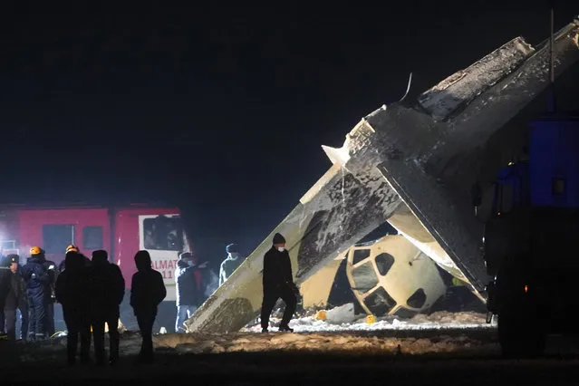 Emergency employees work at the side of the crashed Soviet-built An-26 two-engine turboprop at the airport of Kazakhstan's largest city, Almaty, Kazakhstan, Saturday, March 13, 2021. Officials in Kazakhstan say a plane operated by the country's state security agency has crashed, killing four crew members and injuring the other two. The Emergencies Ministry said the Soviet-built An-26 two-engine turboprop crashed while trying to land Saturday at the airport of Kazakhstan's largest city, Almaty. (Photo by Vladimir Tretyakov/AP Photo)