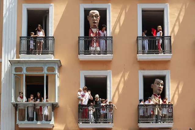 Cabezudos (big-head) stand on the balconies in the final day of the San Fermin Festival, in Pamplona, northern Spain on July 14, 2022. On each day of the festival six bulls are released at 8:00 a.m. (0600 GMT) to run from their corral through the narrow, cobbled streets of the old town over an 850 meters (yard) course. Ahead of them are the runners, who try to stay close to the bulls without falling over or being gored. (Photo by Miguel Riopa/AFP Photo)