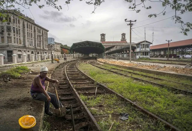 A worker takes a break next to the rails in restoration of the central train station In Havana, Cuba, Thursday, June 17, 2021. (Photo by Ramon Espinosa/AP Photo)