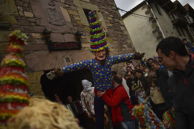 A giant called “Miel Otxin”, a symbol of the carnival is carried during the ancient rural carnival in the small Pyrenees village of Lantz, northern Spain, Sunday, February 7, 2016. (Photo by Alvaro Barrientos/AP Photo)