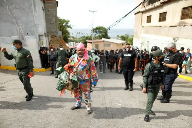 A member of Venezuelan brotherhood “Dancing Devils” waits in front of the Bolivarian National Guard who blocks access to the center of town during their annual Corpus Christi celebration with a call for the end of the coronavirus disease (COVID-19), in Naiguata, Venezuela on June 3, 2021. (Photo by Leonardo Fernandez Viloria/Reuters)