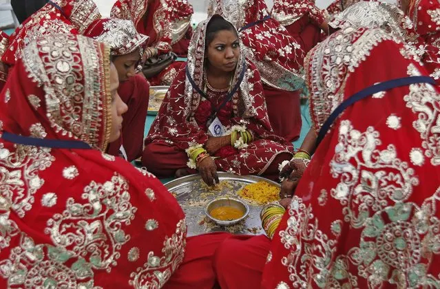 Muslim brides eat food during a mass marriage ceremony in Ahmedabad, India, February 7, 2016. (Photo by Amit Dave/Reuters)