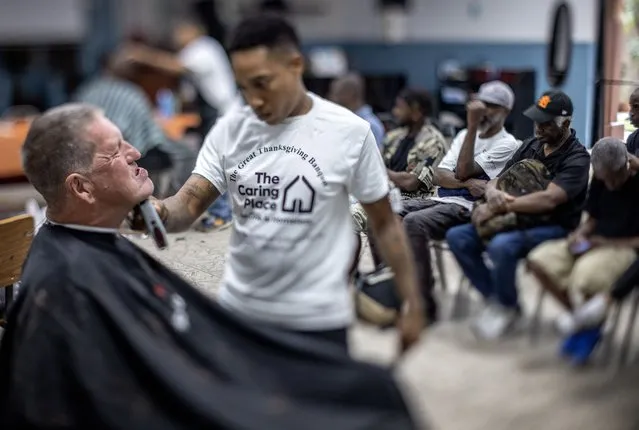 A picture taken with a tilt-shift lens shows Miami area homeless people getting free a haircut before entering the Great Thanksgiving Banquet offered by Miami Mission Rescue foundation in Miami, Florida, USA, 23 November 2023. According to the organizers, the Caring Place at Miami Rescue Mission and over 130 volunteers are providing traditional Thanksgiving meals for the homeless and hungry of Miami-Dade and Broward County at The Great Thanksgiving Banquet outreach. (Photo by Cristobal Herrera-Ulashkevich/EPA)