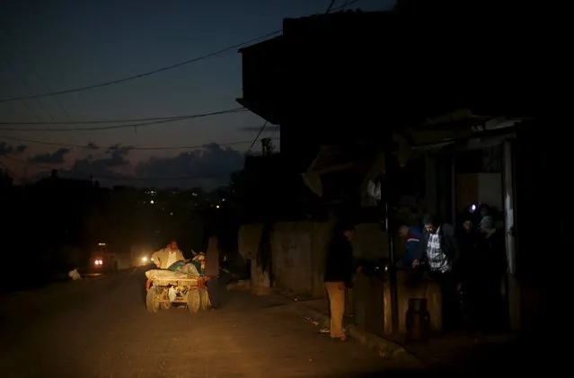 A vendor fries Falafel as Palestinians wait to buy during a power cut at a street lit by passing cars in the northern Gaza Strip, February 10, 2016. (Photo by Mohammed Salem/Reuters)