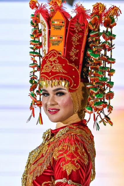 A model presents a creation of traditional Indonesian attire as part of the Aceh Cultural Week in Banda Aceh on November 9, 2023. (Photo by Chaideer Mahyuddin/AFP Photo)