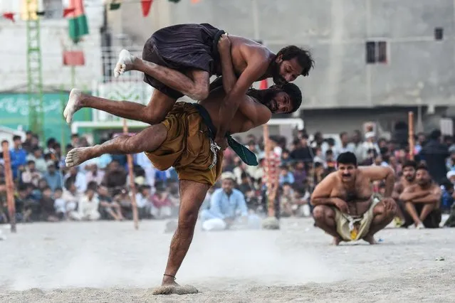 Wrestlers compete in a 'Sindhi Malakhra' wrestling match, a local ancient form of wrestling originated in Pakistan's Sindh region, during a local tournament in Karachi on November 14, 2023. (Photo by Asif Hassan/AFP Photo)