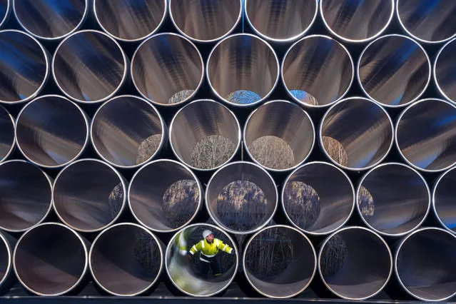 A worker inspects stacks of pipes weighing several tons each which will be used for the construction of the Nord Stream gas pipeline in the Sassnitz-Mukran harbour in northeastern Germany, 06 December 2016. The first sections of the 1,200 kilometer pipeline were delivered in late October 2016. Around 2,000 of a total 90,000 steal pipe components are currently being stored on the island of Ruegen. According to the Gazprom subsidiary Nord Stream 2 AG, the assembly works will begin in mid-2017. So far the political controversial pipeline, which will have a total capacity of some 55 billion cubic meters, has not recieved building permission. (Photo by Jens Buettner/EPA)