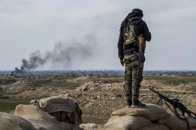 A fighter with the US-backed Syrian Democratic Forces (SDF) keeps position during an operation to expel Islamic State group (IS) jihadists from the Baghouz area in the eastern Syrian province of Deir Ezzor on February 13, 2019. Syrian fighters backed by artillery fire from a US-led coalition battled a fierce jihadist counteroffensive as they pushed to retake a last morsel of territory from the Islamic State group in an assault lasting days. More than four years after the extremists declared a “caliphate” across large parts of Syria and neighbouring Iraq, several offensives have whittled that down to a tiny scrap of land in eastern Syria. (Photo by Fadel Senna/AFP Photo)