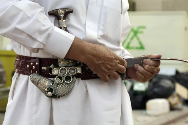 In this April 16, 2015 photo, Misfer al-Qahtani, a 70 year-old retired National Guard officer wears his traditional Saudi dagger at al-Aqeeliya open-air auction market, in Riyadh, Saudi Arabia. (Photo by Hasan Jamali/AP Photo)