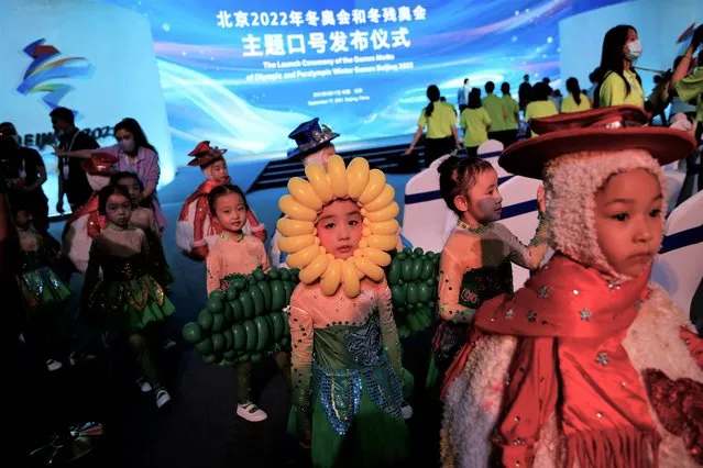 Young performers dressed in costumes leave following a ceremony unveiling the slogan for the Beijing 2022 Winter Olympic Games, in Beijing, China on September 17, 2021. (Photo by Tingshu Wang/Reuters)