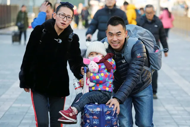 A girl is pushed on traveler's suitcase at the Beijing Railway Station in central Beijing, China January 27, 2017 as China gears up for Lunar New Year, when hundreds of millions of people head home. (Photo by Damir Sagolj/Reuters)