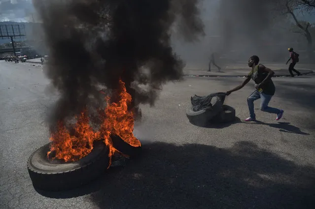 A demonstrator prepares to torch another tire on the fourth day of protests in Port-au-Prince, February 10, 2019, against Haitian President Jovenel Moise and misue of Petrocaribe fund. (Photo by Héctor Retamal/AFP Photo)