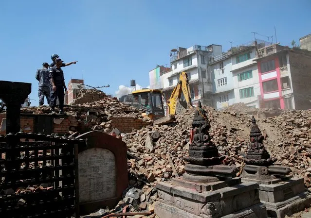 Nepalese police personnel look on as an excavator is used to dig through rubble to search for bodies following Saturday's earthquake in Kathmandu, Nepal, April 27, 2015. (Photo by Danish Siddiqui/Reuters)