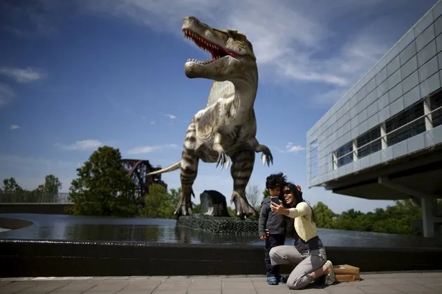 People photograph themselves in front of an animatronic dinosaur at the William J. Clinton Presidential Center & Park in Little Rock, Arkansas, United States April 27, 2015. (Photo by Lucy Nicholson/Reuters)