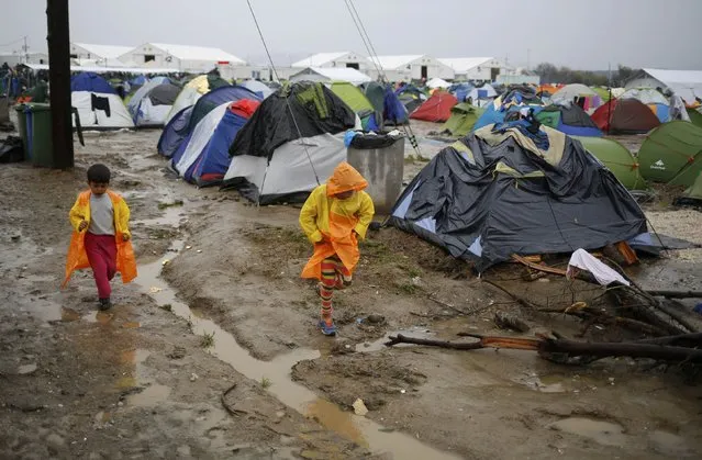 Migrants walk in a mud at a makeshift camp on the Greek-Macedonian border, near the village of Idomeni, Greece March 10, 2016. (Photo by Stoyan Nenov/Reuters)