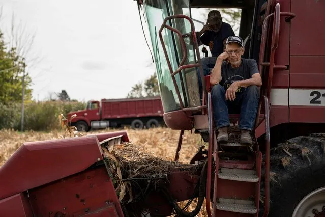 Dale Nething, 86, waits on the steps as his son Don Nething, 62, troubleshoots the combine harvester after it breaks down while being used to harvest corn in Ravenna, Ohio, U.S., October 11, 2021. (Photo by Dane Rhys/Reuters)
