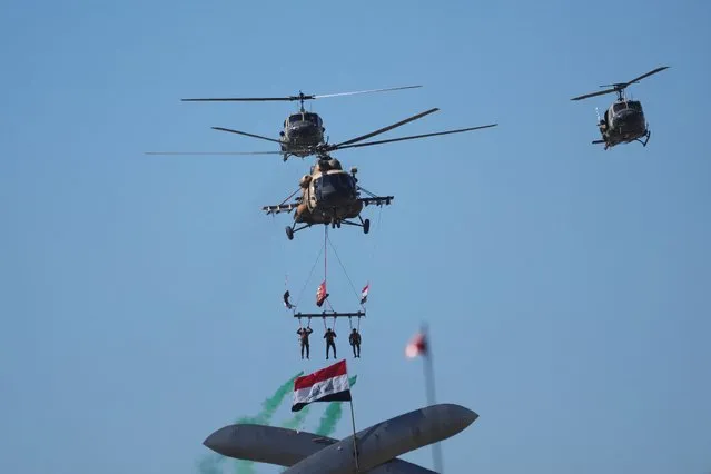 Iraqi Army helicopters fly in formation at the Monument of the Unknown Soldier during the Army Day celebrations in Baghdad, Iraq, Saturday, January 6, 2024. The Iraqi Army was activated on January 6, 1921 while under British rule. (Photo by Hadi Mizban/Pool via Reuters)