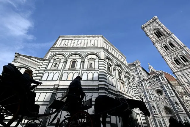 A horse-drawn carriage transports tourists at Piazza Del Duomo in Florence, on February 15, 2024. A lot of historic workshops fear to close in Florence due to over tourism. Calls for urgent action to protect the city centre, a UNESCO site, intensified last month after a museum director said “hit and run” tourism had transformed Florence into a “prostitute”. Some 1.5 million tourists flocked to the city last summer, up 6.6 percent on a year, while an increasing number of independent shops and residential apartments are being transformed into fast food outlets and Airbnbs. (Photo by Alberto Pizzoli/AFP Photo)