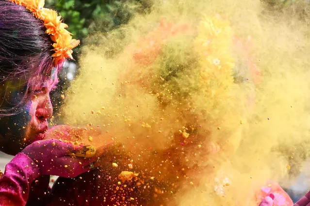 A woman is smeared with 'Gulal' as she celebrates Holi, the Hindu spring festival of colours, in Kolkata on March 25, 2024. (Photo by Dibyangshu Sarkar/AFP Photo)