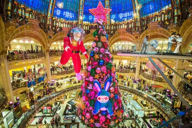 The traditionnal giant Christmas tree of the Galeries Lafayette department store stands under its great dome in Paris, France, 20 December 2021. French President Macron has announced a series of health restriction measures in anticipation of the arrival of the new Omicron variant and to combat a resurgence of the coronavirus disease (COVID-19) pandemic. (Photo by Christophe Petit Tesson/EPA/EFE)