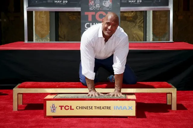 Actor Dwayne “The Rock” Johnson poses with his hands in cement during his hand and footprints ceremony in the forecourt of the TCL Chinese Theatre in celebration of his new movie “San Andreas”, in Hollywood, California May 19, 2015. (Photo by Danny Moloshok/Reuters)