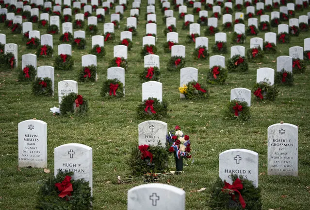 Balsam fir wreaths lie on tombstones in Section 60 at Arlington National Cemetery, on December 18, 2021 in Arlington, Virginia. The 30th annual “Wreaths Across America” project places wreaths on the more than 250,000 tombstones of military servicemen and women at Arlington National Cemetery. (Photo by Al Drago/Getty Images)