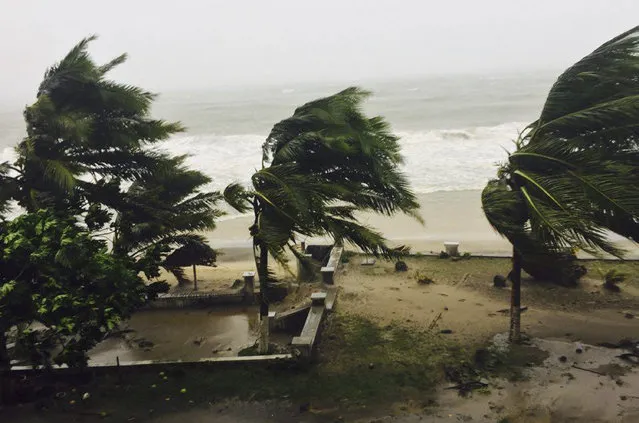 Trees are lashed by strong winds in Sambava, Madagascar Tuesday, March 7, 2017 as heavy rains and strong winds from a cyclone hit northeast Madagascar, raising concerns about flooding and landslides. Aid workers were on alert as Cyclone Enawo lashed the coastline. The storm was expected to move south through the island nation for several days, affecting the capital of Antananarivo along the way. (Photo by Manny Horsford/AP Photo)