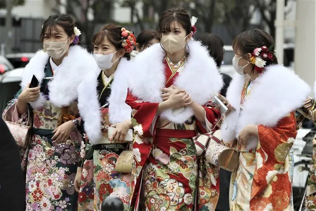 Women who have just turned and will be 20 years old this year clad in Japan's traditional kimono outfits walk on the street during a ceremony to celebrate Coming of Age Day in Yokohama, Monday, January 10, 2022. (Photo by Koji Sasahara/AP Photo)