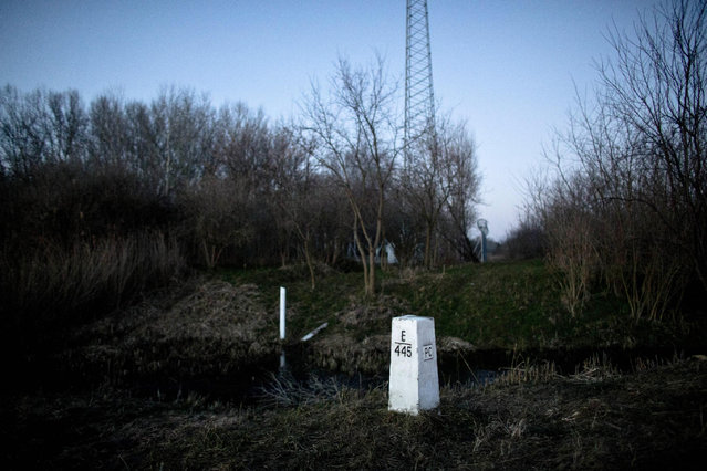 FILE - In this Feb. 17, 2015 file photo a Serbian and a Hungarian border marker are seen meters of each other in a field close to Hajdukovo, 150 kilometers north of Belgrade, Serbia. Hungary's foreign minister said Wednesday, June 17, 2015 the government is considering building a 4-meter-high (13-foot-high) fence along border with Serbia to stop the flow of migrants reaching the country. (AP Photo/Marko Drobnjakovic)