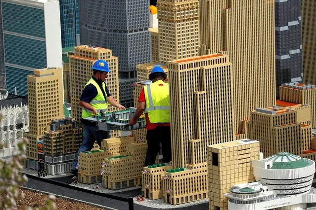 Workers carry the skating rink portion of Rockefeller Center as they work on the New York City section of the “Miniland” area of the new Legoland New York Resort theme park during a press preview of the park, which is currently under construction, with plans to open to the public in the summer of 2021 in Goshen, New York, U.S., April 28, 2021. (Photo by Mike Segar/Reuters)