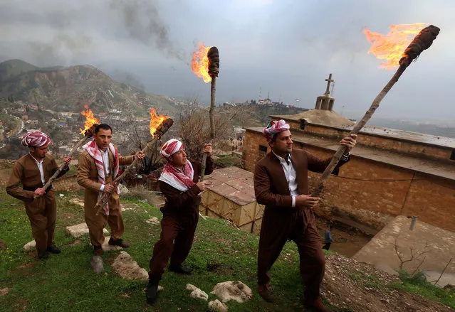 Iraqi Kurds holding lit torches walk up a mountain in the town of Akra, 500 km north of Baghdad, on March 20, 2017 as they celebrate the Noruz spring festival. The Persian New Year is an ancient Zoroastrian tradition celebrated by Iranians and Kurds which coincides with the vernal (spring) equinox and is calculated by the solar calender. (Photo by Safin Hamed/AFP Photo)