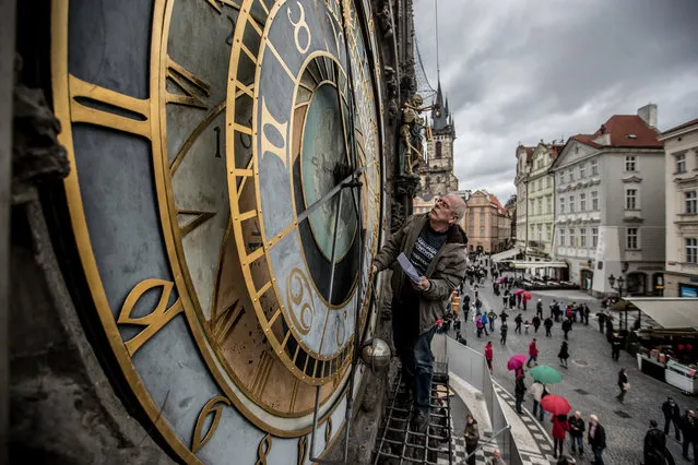 Clockmaker Petr Skala checks the Prague's Old Town astronomical clock, during the symbolic start of renovation of the Old Town hall tower at the Old Town Square in Prague, Czech Republic, 06 April 2017. The astronomical clock will be restored into form from the end of 19th century with original elements. Some parts will have new colours and propulsion of clock machine will be changed too. The reconstruction and restoration works of Prague's Old Town hall and astronomical clock are planned to take 18 months with costs of about 50 million Czech crowns (1,85 million euros). The Old Town hall was built in 1338. (Photo by Martin Divisek/EPA)