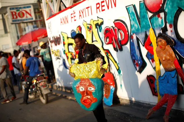 A street vendor holds a carnival decoration made of papier mache in a street of Port-au-Prince, Haiti, February 25, 2017. (Photo by Andres Martinez Casares/Reuters)