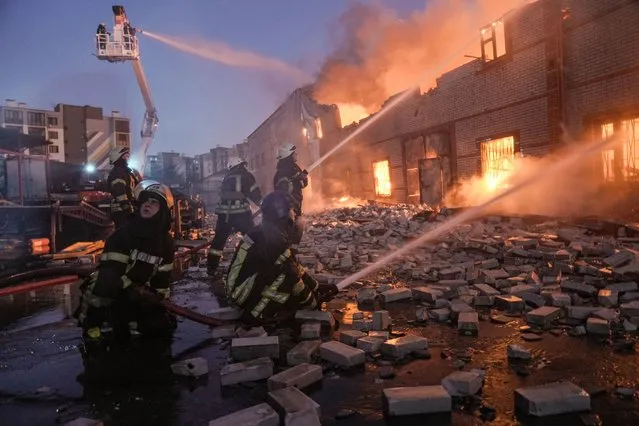 Ukrainian firefighters extinguish a blaze at a warehouse after a bombing in Kyiv, Ukraine, Thursday, March 17, 2022. (Photo by Vadim Ghirda/AP Photo)