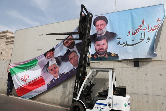 A man puts up a banner depicting late Iranian President Ebrahim Raisi who was killed along with other officials in a helicopter crash, at the Iranian embassy in Beirut, Lebanon on May 22, 2024. (Photo by Mohamed Azakir/Reuters)