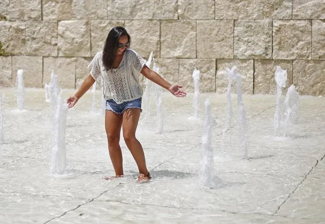 A woman cools off in a fountain during a hot summer day in Rome, Italy, July 17, 2015. A heat wave coming from Africa is spreading across Italy with temperatures forecast to reach 40 degrees Celsius (104 degrees Fahrenheit), reported local weather officials. (Photo by Max Rossi/Reuters)