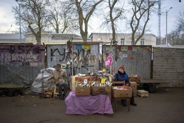 A vendor selling dried fish at her street stall waits for customers in Odessa, Ukraine, Thursday, February 17, 2022. (Photo by Emilio Morenatti/AP Photo)