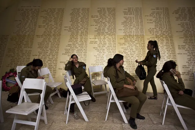 Israeli soldiers sit in front of a monument engraved with names of fallen Israeli soldiers, as they wait for the start of a ceremony marking Memorial Day in Jerusalem May 4, 2014. (Photo by Nir Elias/Reuters)