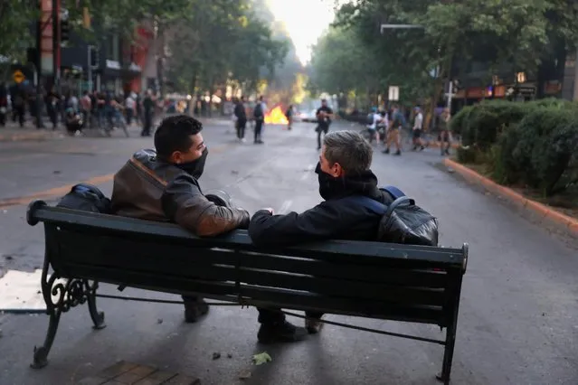 People sit on a bench in the middle of a road as demonstrators protest against Chile's government in Santiago, Chile on November 6, 2019. (Photo by Henry Romero/Reuters)