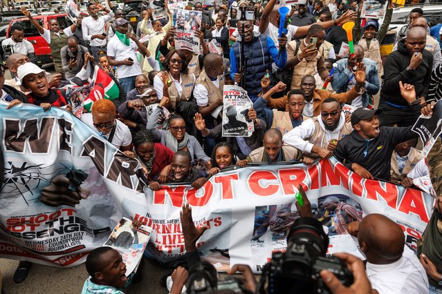 Journalists take part in a street protest chant as they staged a brief sit down on a street with a banner written “We are Not Criminals” as they sang and chanted calling for protection of journalists and respect of media freedoms following several attacks on journalists by police during ongoing anti-government demonstrations around the country, in Nairobi on July 24, 2024. (Photo by Tony Karumba/AFP Photo)