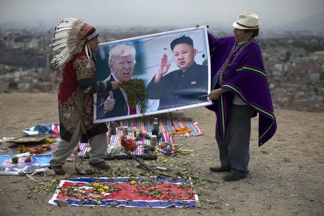 Shamans holding posters of U.S. President Donald Trump, left, and North Korean leader Kim Jong, perform a ceremony on Morro Solar in Lima, Peru, Monday, June 12, 2017. The shamans said they performed the ritual for peace between the U.S. and North Korea. (pHOTO BY Martin Mejia/AP Photo)